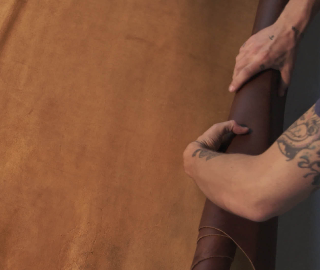 Hands rolling leather